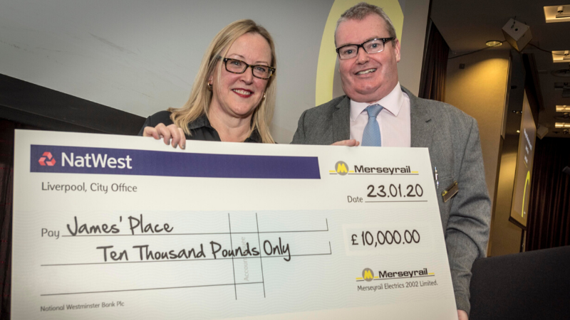 Woman and man holding a cheque and smiling