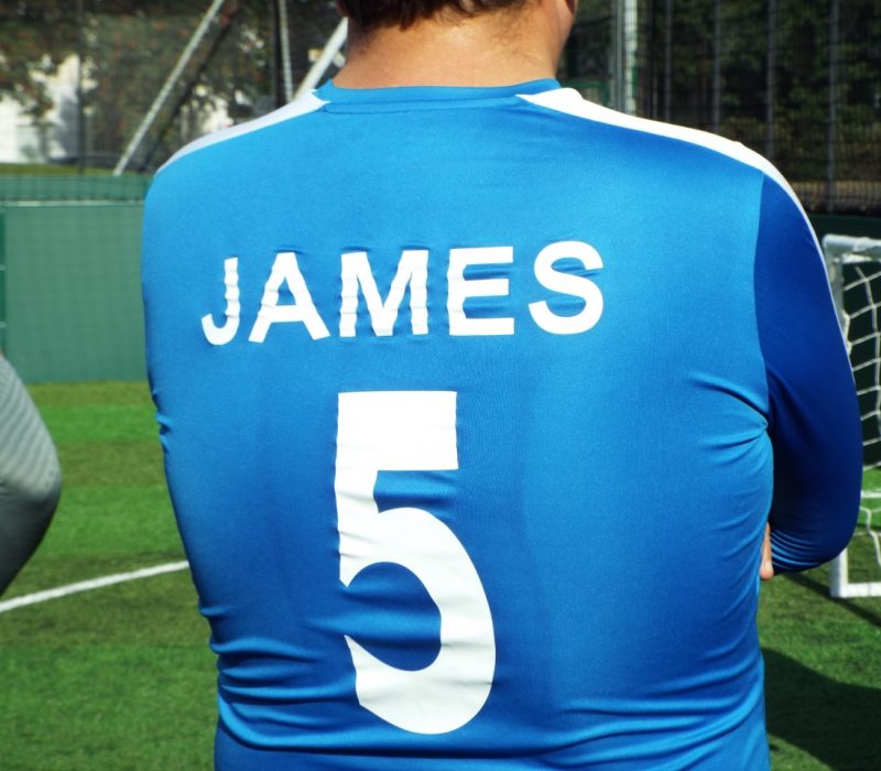 Man wearing football shirt with number 5 and James on the back