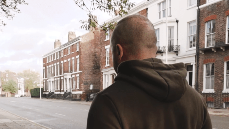 Man walking up street.