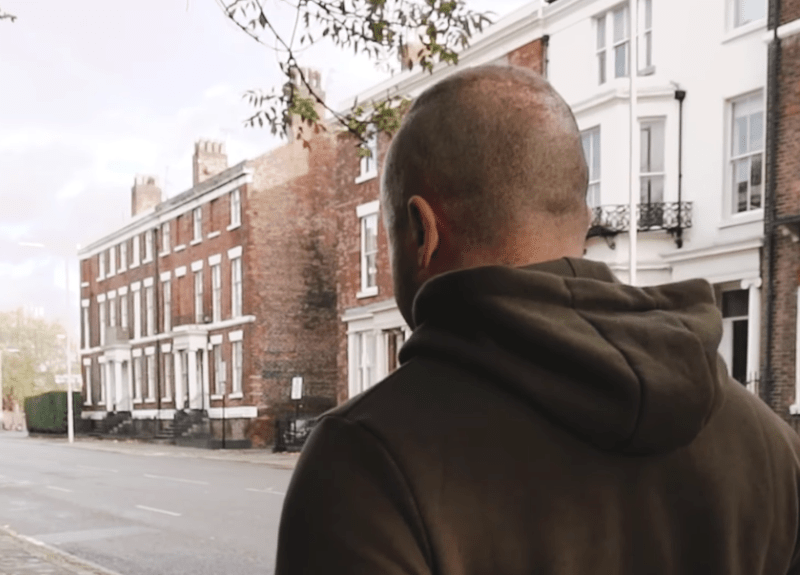 Man walking up street.