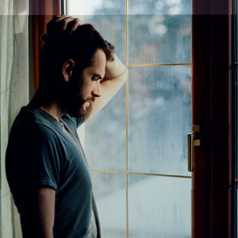 Man looking sad by window