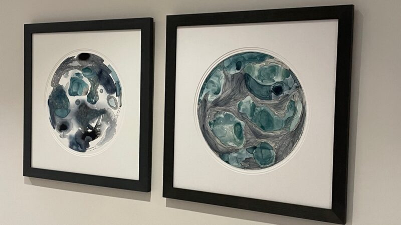 Two pieces of abstract round artwork on a wall