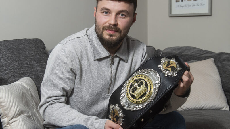 Man holding Muay Thai boxing belt