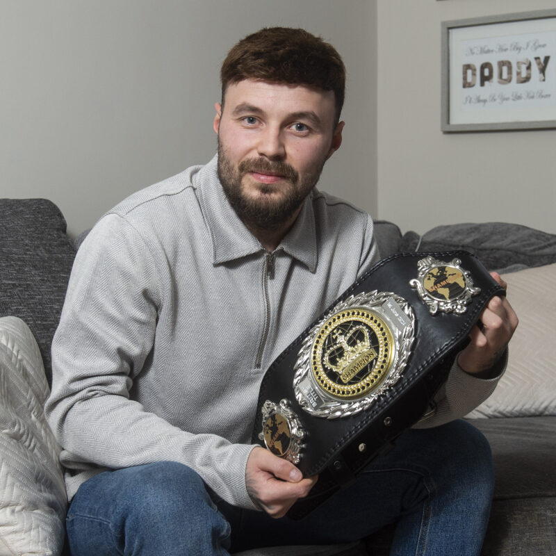 Man holding Muay Thai boxing belt