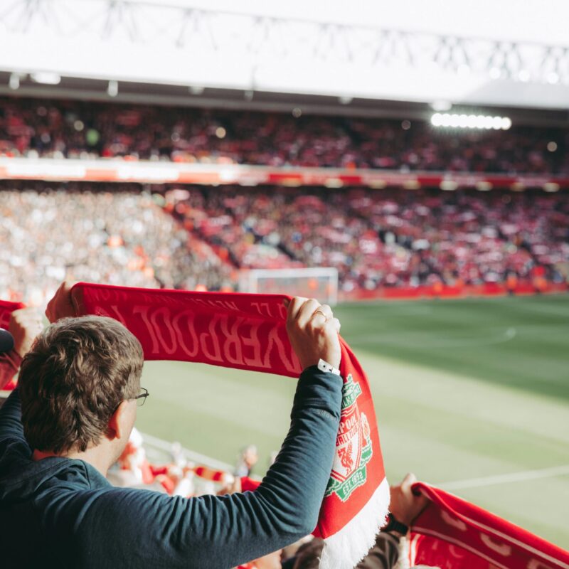 Man holding scarf at football match