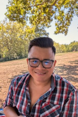 Man in check shirt smiling at camera