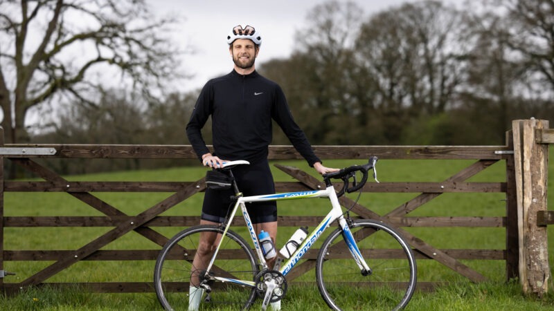 Man leaning against gate with bike